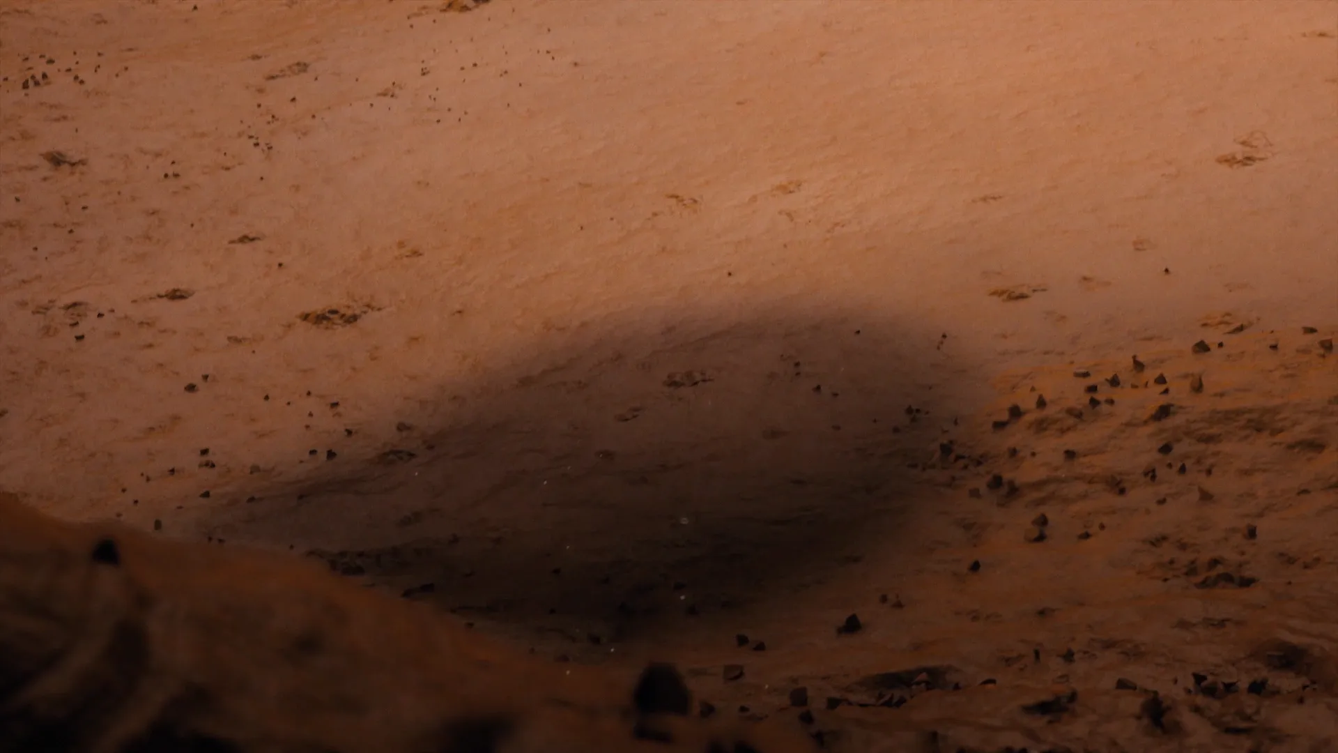 Still frame from a film made for Valio Herkku. The shadow of a giant spoon can be seen against the planet surface.
