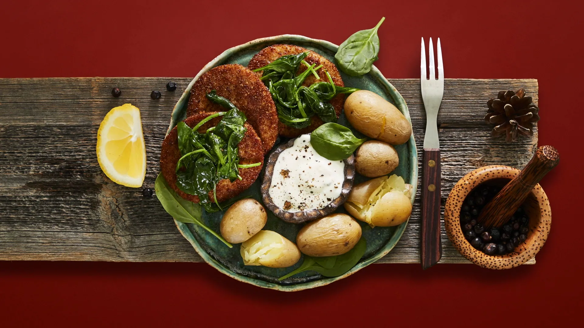 A delicious photograph of a plate with fried fish steaks, potatoes and sauce and herbs.